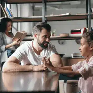 A co-parenting father spends quality time with his daughter at a family-friendly workspace