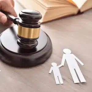 Court gavel and paper cutout figures symbolize legal decisions in co-parenting arrangements