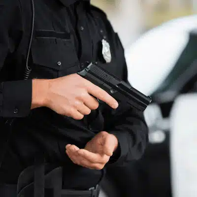 Police officer handling handgun safely, demonstrating law enforcement context of gun charge in Texas