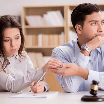 A couple signs legal documents during separation process, highlighting collaborative divorce vs traditional divorce considerations