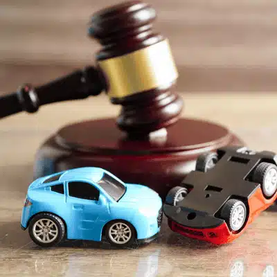 Toy cars and gavel symbolize legal proceedings and claims following motor vehicle collision disputes