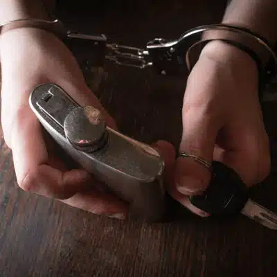 Handcuffed hands clutch flask and car key; asks can you get a dui from video